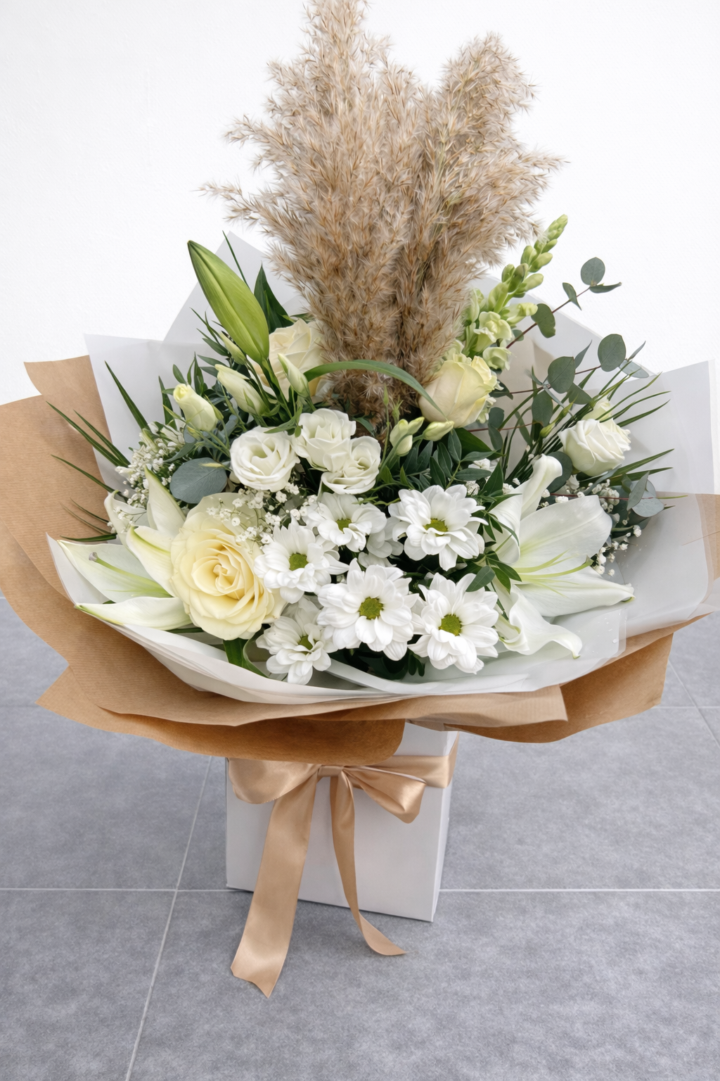 Bouquet of white and green flowers with greenery on a grey surface