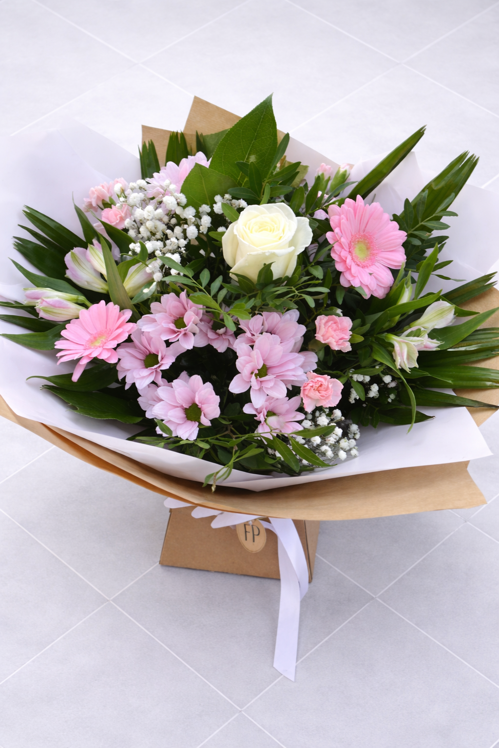 Bouquet of pink and white flowers with green leaves on a white background
